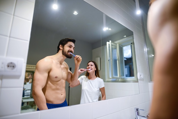 Пара мытья зубов в ванной комнате.