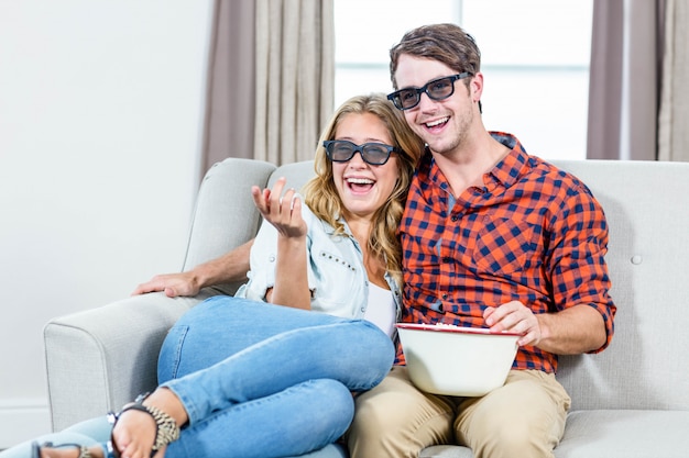 Couple watching a 3D movie in the living room