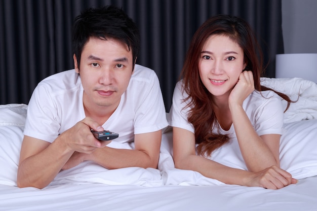 couple watching movie on bed in the bedroom