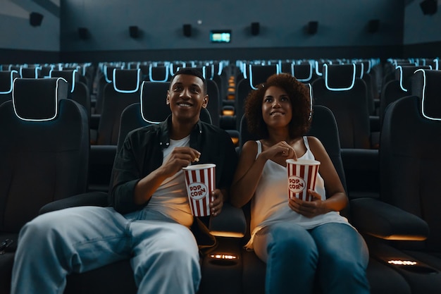 Couple watching movie with popcorn in cinema