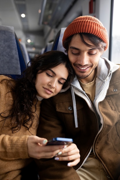 사진 기차로 여행하는 동안 스마트폰으로 무언가를 보고 있는 커플