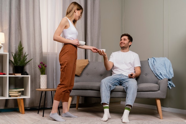 Photo couple watching tv and drinking coffee