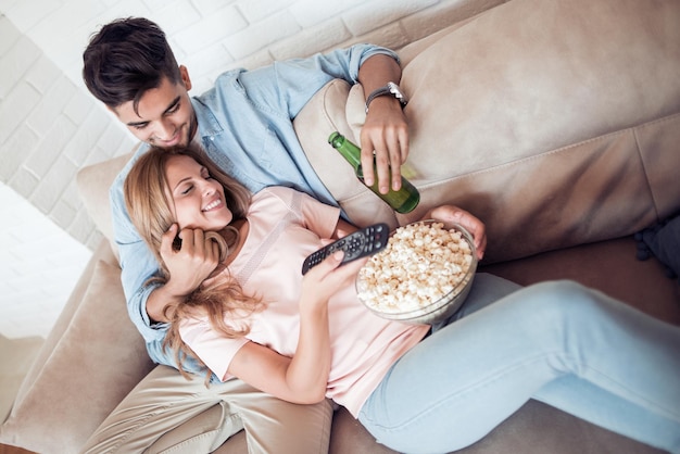 Couple watching TV and eating popcorn