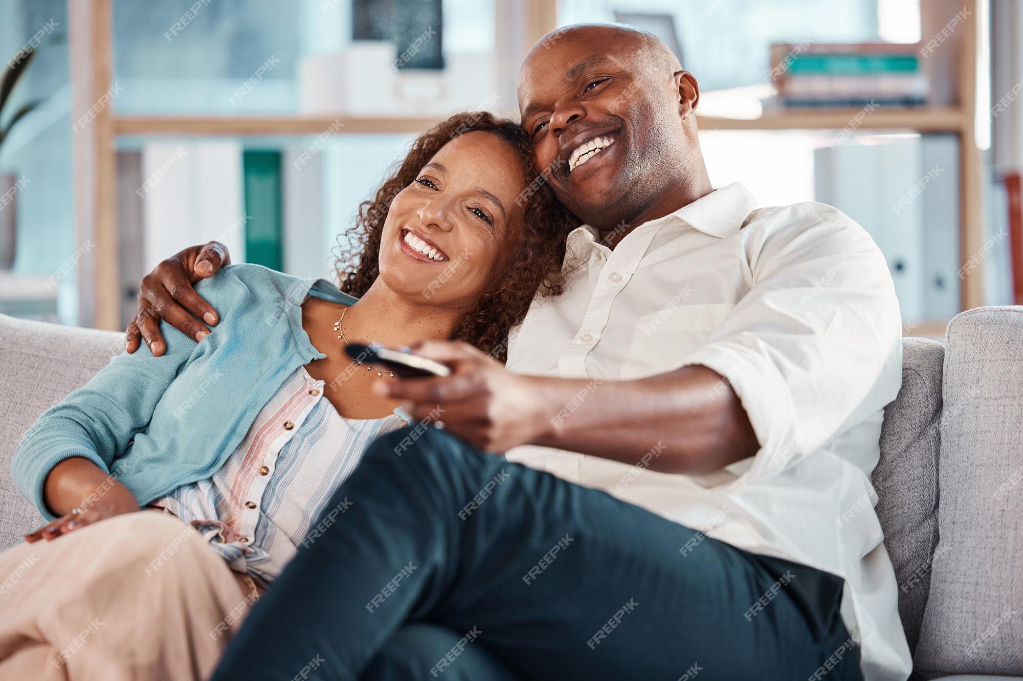 Happy Mixed Race Couple Relax On Couch In Living Room Watch Movie