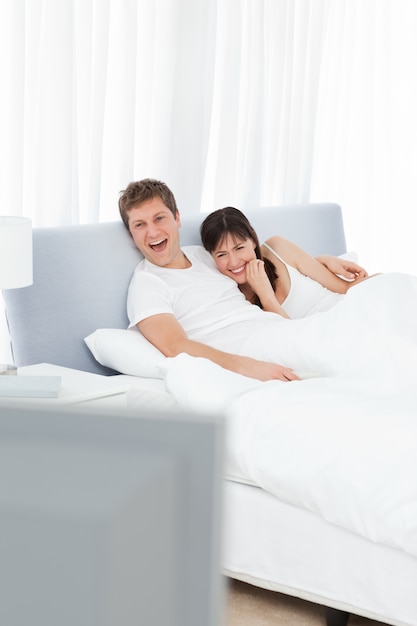 Couple watching tv in their bed