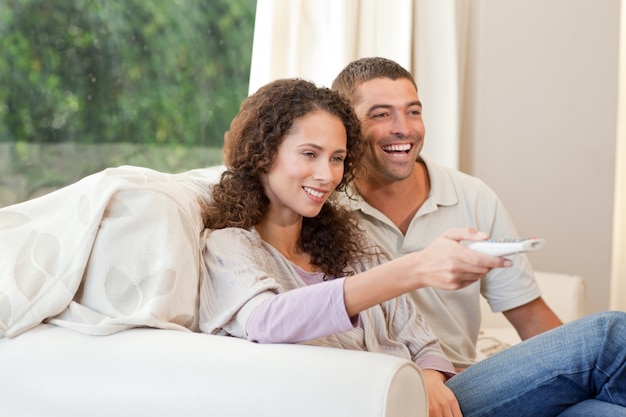 Couple watching tv in their living room at home