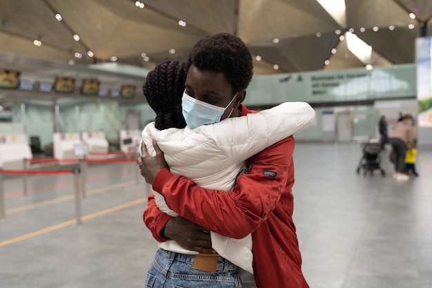 Couple wear face masks hugging each other