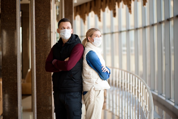 couple wearing masks in an airport lounge