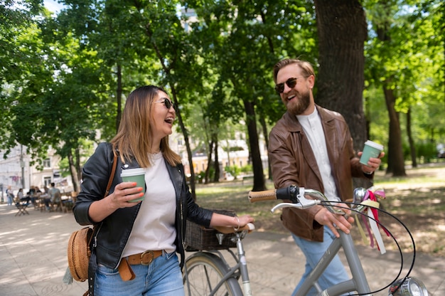 Couple wearing synthetic leather jackets having coffee together outdoors