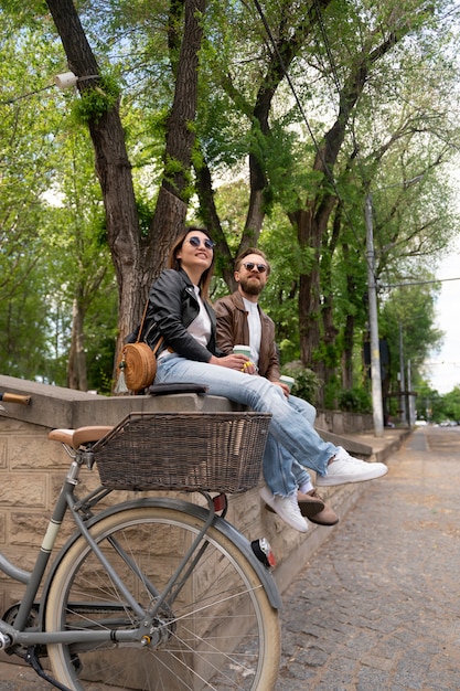 Couple wearing synthetic leather jackets having coffee together outdoors