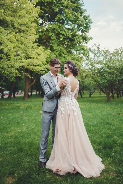 Couple in wedding attire with against the backdrop of the park