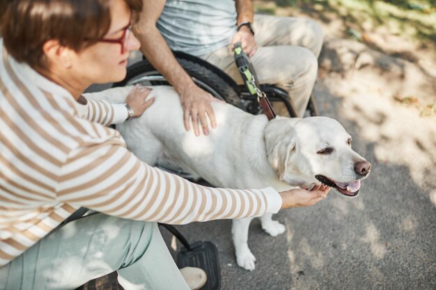 Coppia su sedia a rotelle con cane