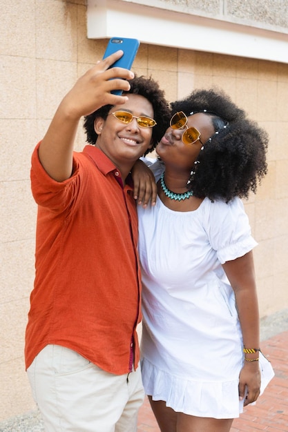 Couple with afro hair taking selfies in the city street