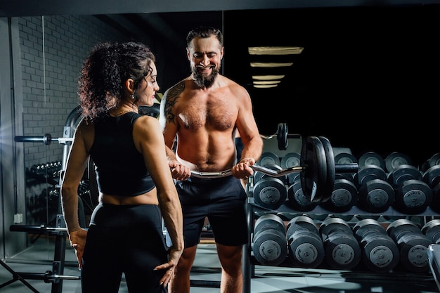 Couple with barbell in gym