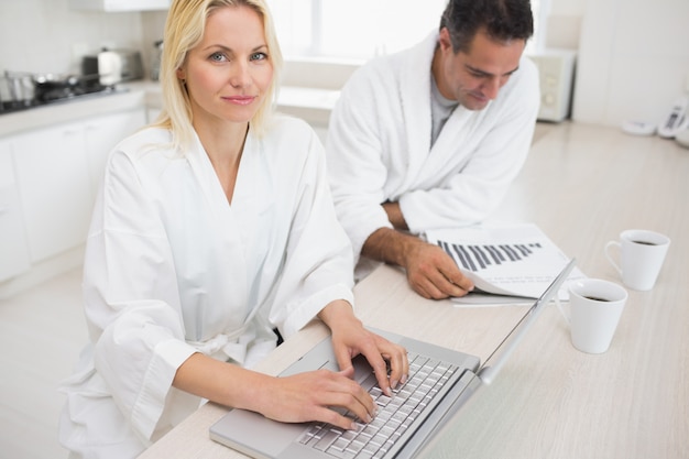 Couple with bills and laptop in the kitchen