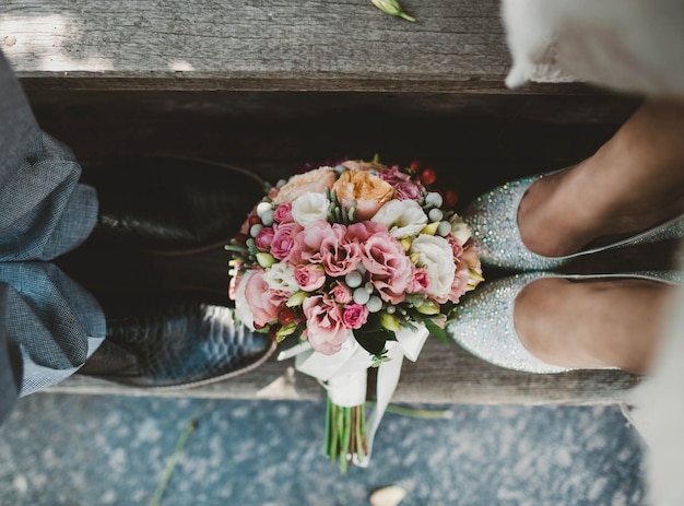 Пара с букетом цветов у их ног