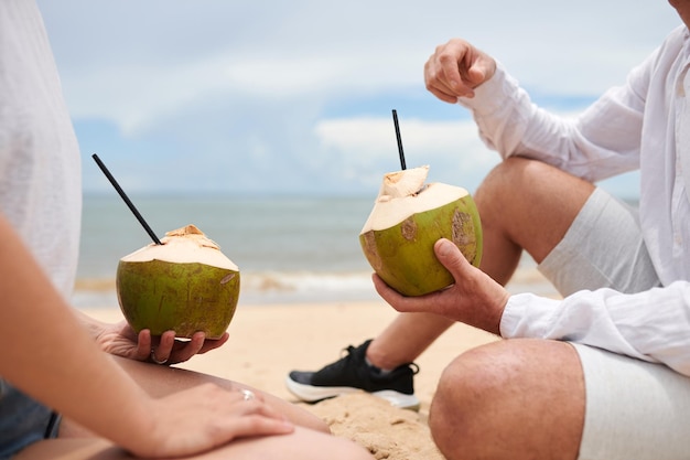 Coppia con noci di cocco sulla spiaggia