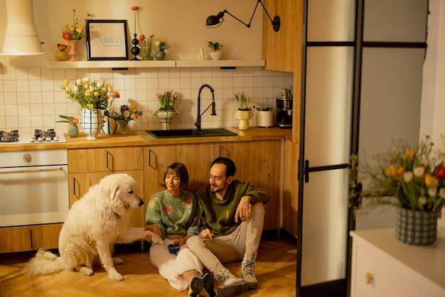 Пара с собакой на кухне дома