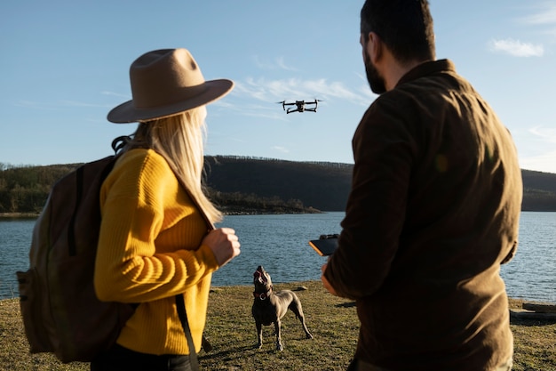 Photo couple with drone and dog medium shot