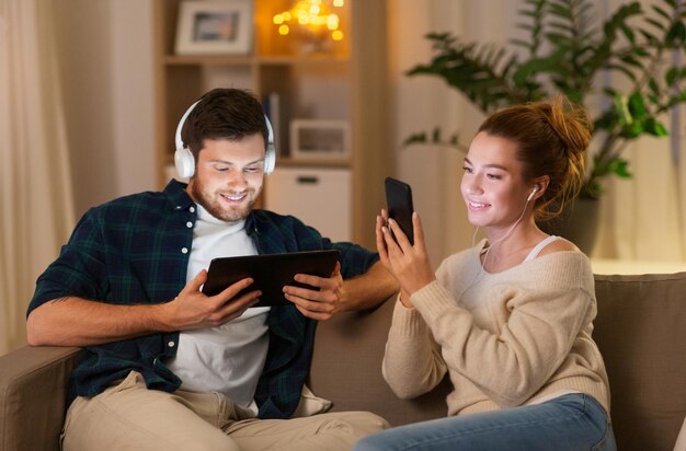 Photo couple with gadgets listening to music at home