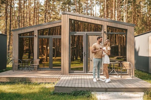 Couple with glasses of red wine standing on the porch