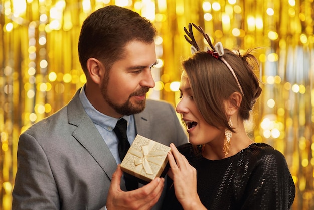 Couple with gold gift on new year or Christmas party