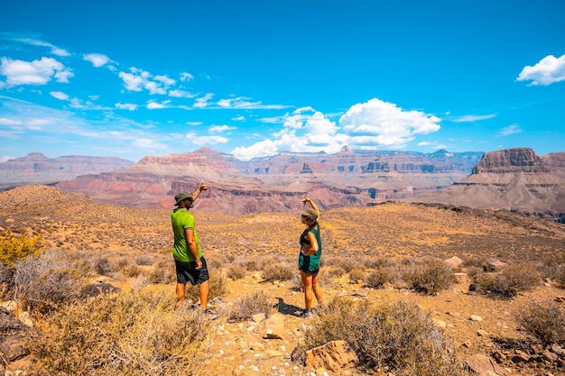 A couple with green shirt resting on the South Kaibab Trailhead trekking. Grand Canyon