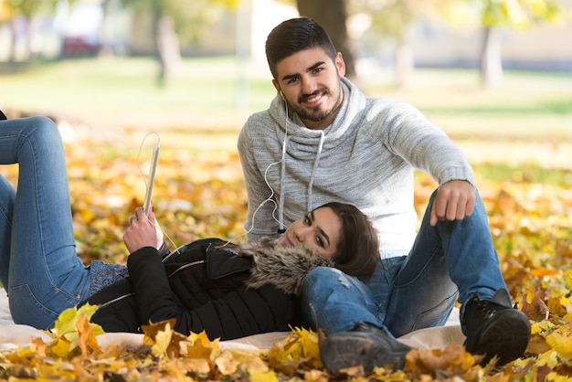 Couple With Headphones Enjoying Music in Autumn Day