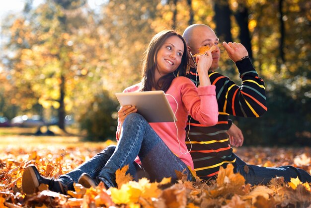 Couple With Headphones Enjoying Music In Autumn