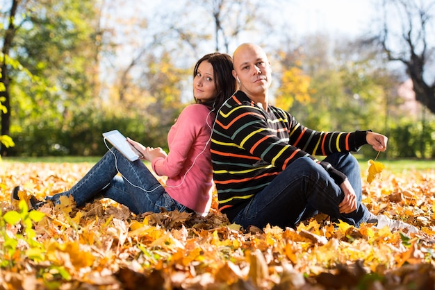 Couple With Headphones Enjoying Music In Autumn