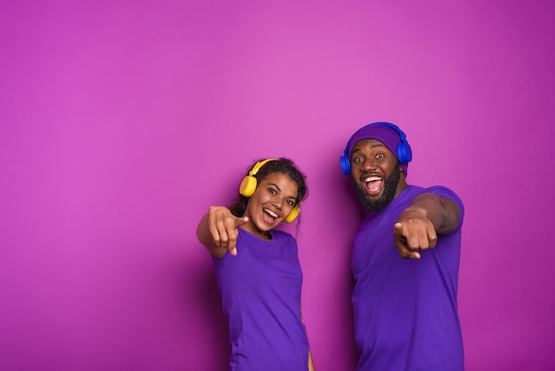 Couple with headset listen to music and have surprised expression.