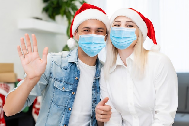 Couple with masks celebrating. Virus and illness protection, home quarantine. COVID-2019.