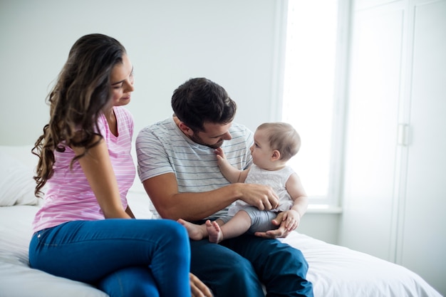 Couple with playing with baby girl in bedroom at home