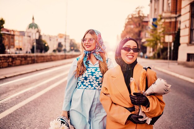 Couple woman one wearing a hijab and a modern yet traditional dress and the other in a blue dress an