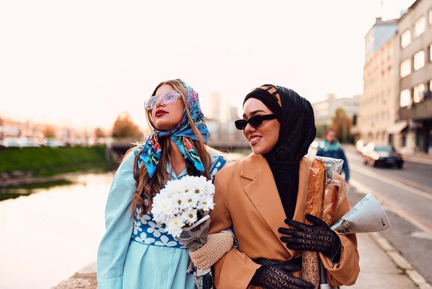 Couple woman one wearing a hijab and a modern yet traditional dress and the other in a blue dress an