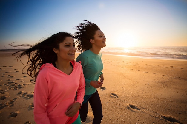 Couple of women running and walking on the beach