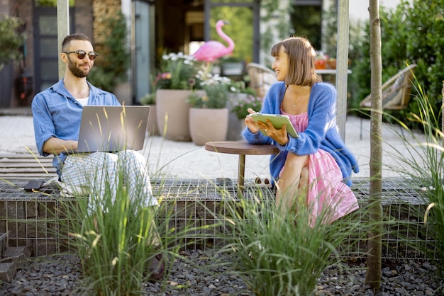 Photo couple work on gadgets at the garden