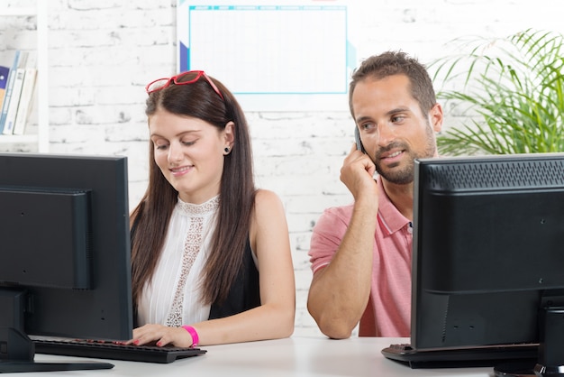 Couple at work in the office, man on phone