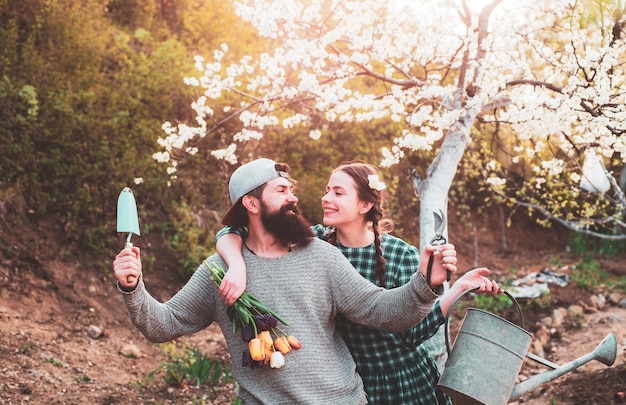 Couple working in garden near flowers garden