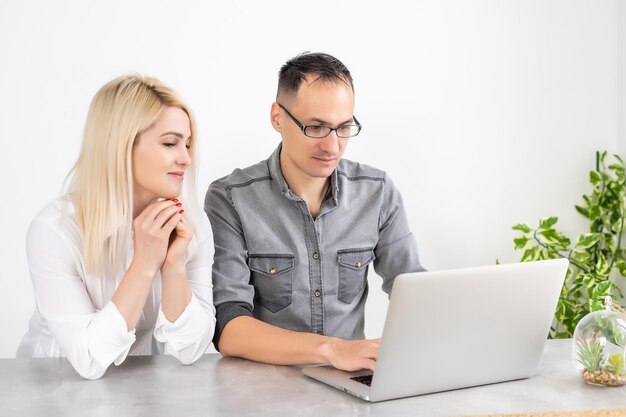 Couple working on laptop in office, woman and man with laptop