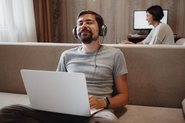 Coppia di lavoro e giocare con il computer portatile a casa