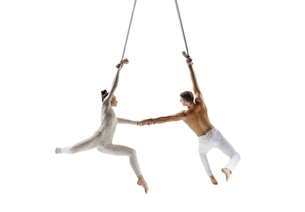 Couple of young acrobats, circus athletes isolated on white studio background.