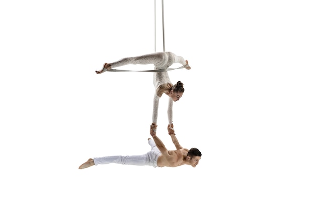 Couple of young acrobats, circus athletes isolated on white studio background.