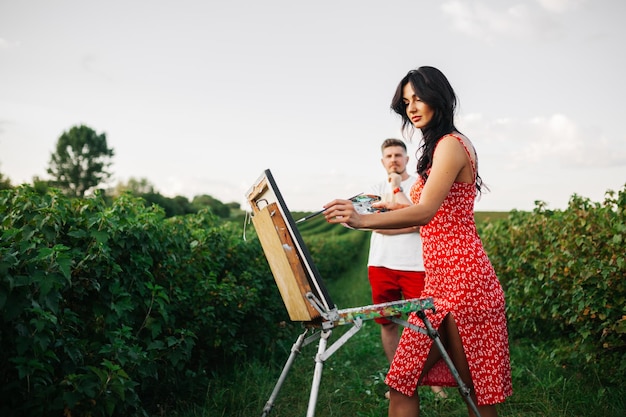 Couple of young artists on color background