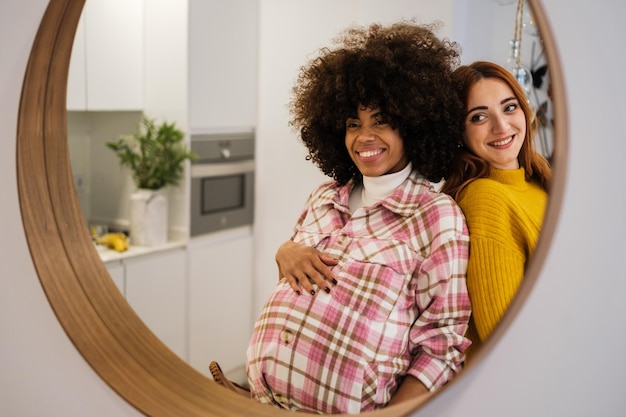 Couple of young girls in the mirror proud of their pregnancy and life together motherhood and lifestyle concept