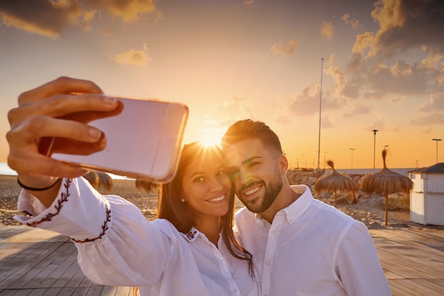 ビーチでの休暇のカップル若いselfie写真