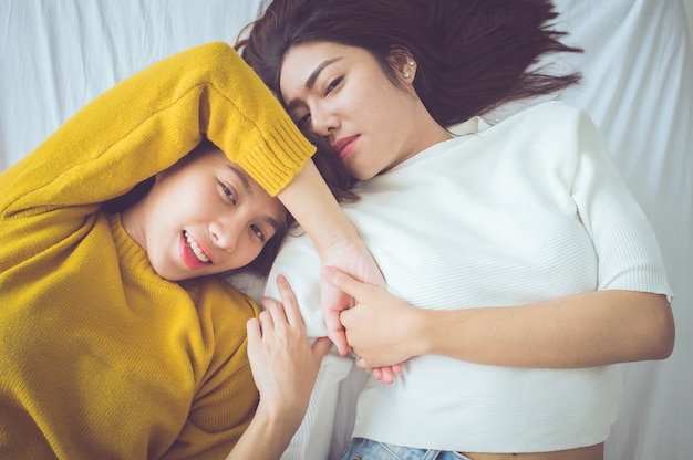 Couple of young women lying on the bed with happiness moment.