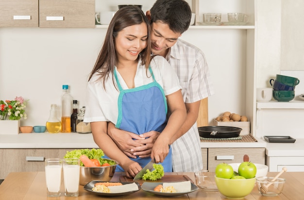 Couples cooking together in the kitchen.