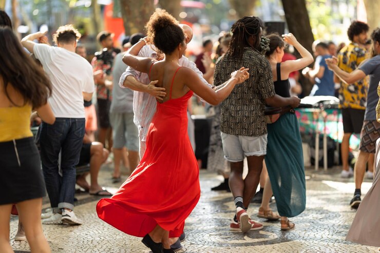 赤い明るいドレスを着た女性が路上で踊るカップル