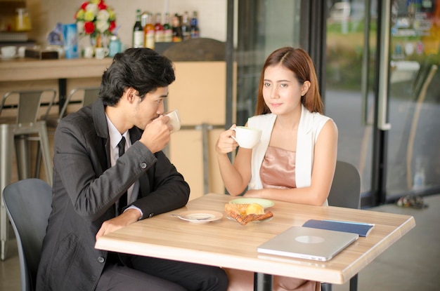 Couples drinking coffee and having bakery in the coffee shop